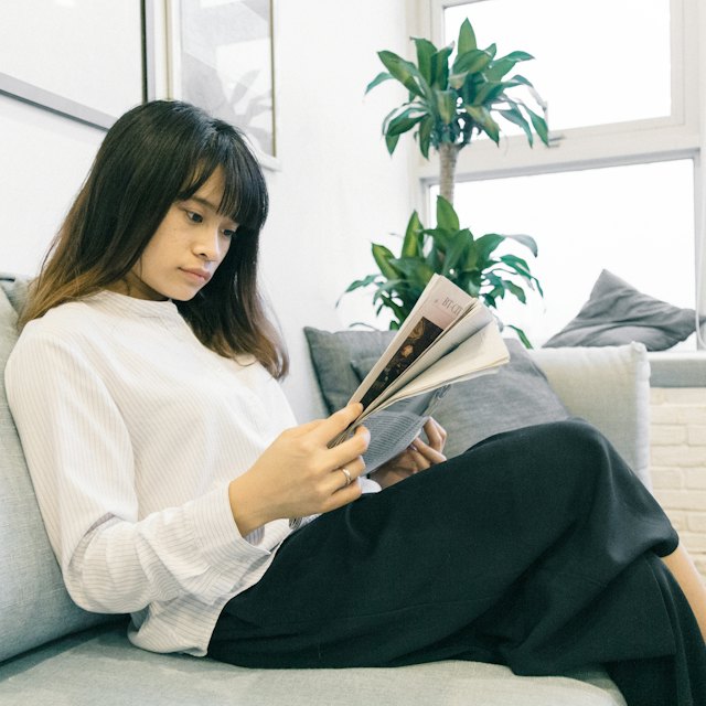 Person reading at home on a sofa